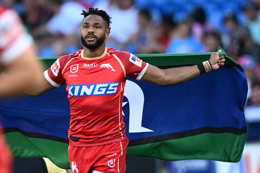 Hamiso Tabuai-Fidow runs out for Multicultural Round with the Torres Strait Islander flag, representing his connection to Saibai Island.