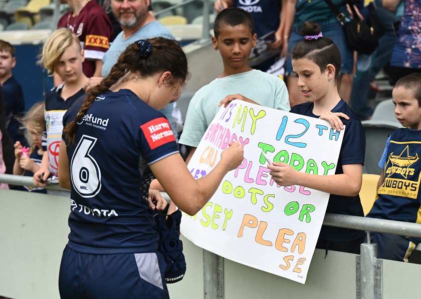 Tillett makes a young fan's day after the Round 7 clash against the Tigers at Queensland Country Bank Stadium.
